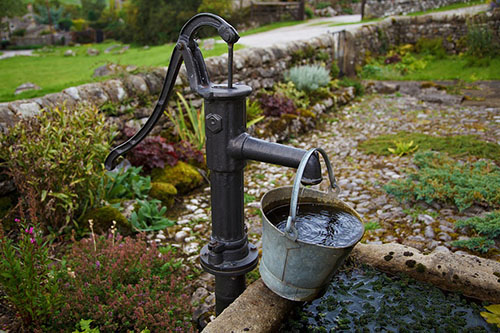 garden tap with full pail of water